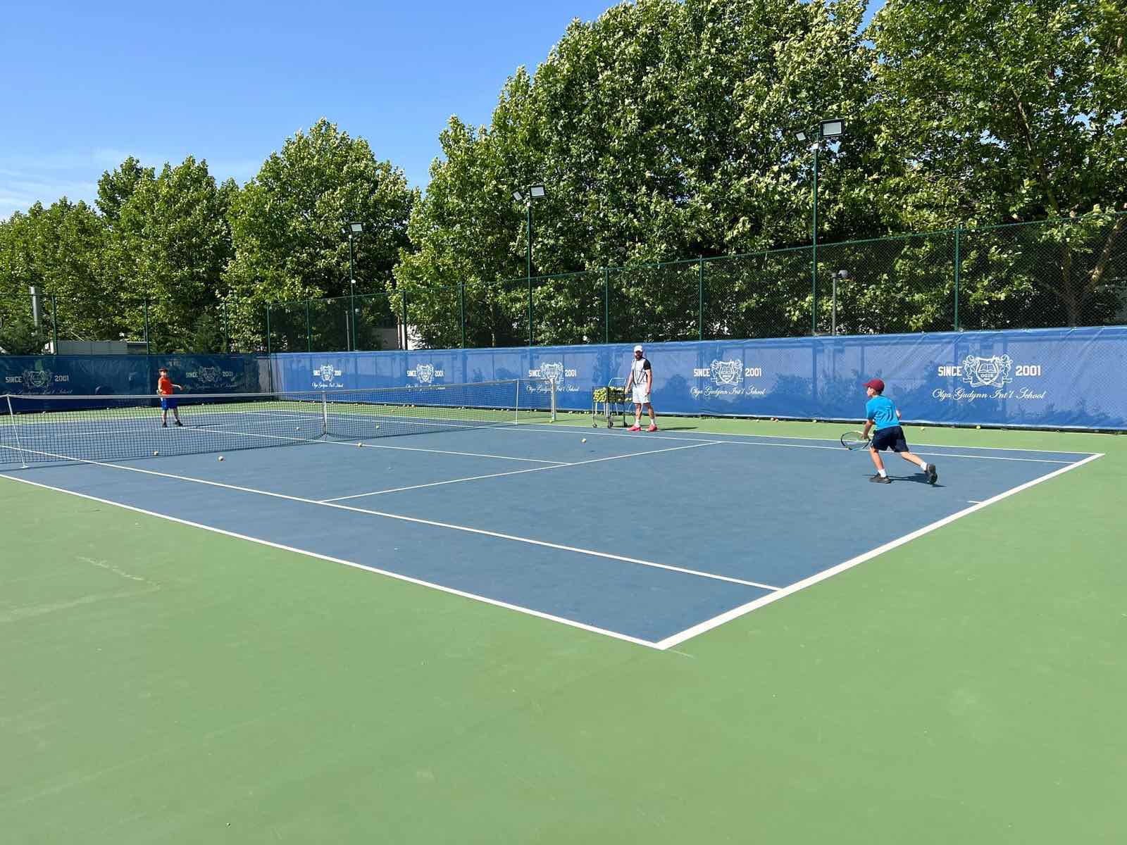 Tabără de vară tenis TC Spark - copii jucând tenis pe terenuri exterioare profesionale în București, România. Antrenamente de tenis pentru juniori cu antrenori calificați.